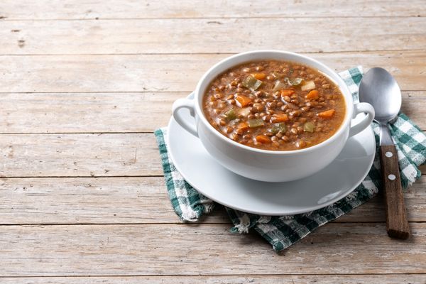 A bowl of lentil soup on a rustic table